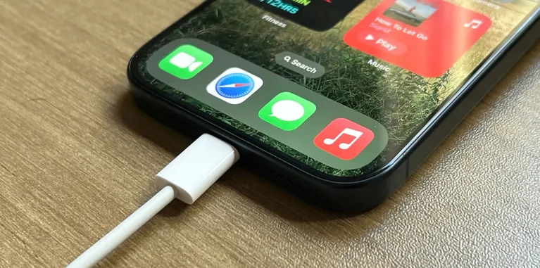 An iPhone connected to a charging cable